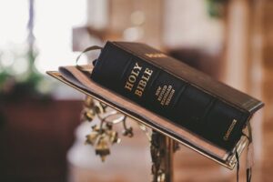 Holy Bible open on a stand inside a church, symbolizing faith and spirituality.